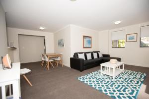 - un salon avec un canapé noir et une table dans l'établissement Bentleigh North Sydney Self Catering, à Sydney