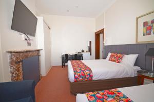 Habitación de hotel con 2 camas y TV de pantalla plana. en The Hallows Accommodation, en Bathurst