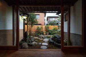 - une vue sur le jardin depuis une porte ouverte dans l'établissement Kenrokutei Oyado, à Kanazawa