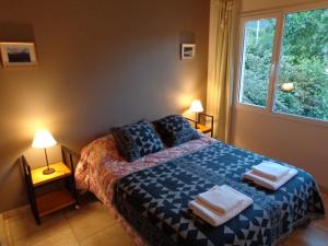 a bedroom with a bed with towels on it at Casas con vista al Piltri in El Bolsón