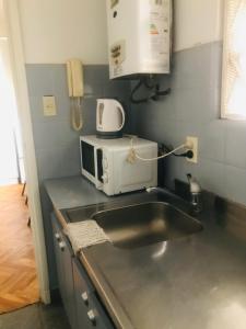 cocina con fregadero y microondas en Apartamento Billinghurts Excelente Ubicacion en Buenos Aires