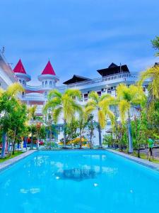 a large blue swimming pool in front of a large building at Landcons Hotel & Resort in Pantai Cenang