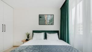 a bedroom with a large bed with green curtains at Stylish Apartment in Zverynas in Vilnius