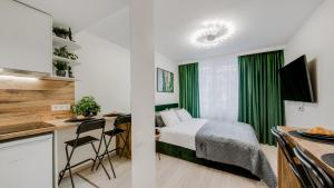 a bedroom with a bed and a desk and a kitchen at Stylish Apartment in Zverynas in Vilnius