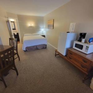 une chambre d'hôtel avec un lit et un four micro-ondes dans l'établissement Early American Motel, à Aurora