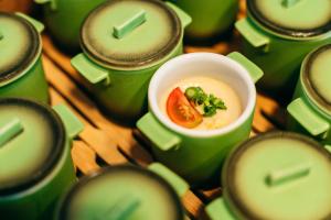 a bowl of soup in a group of green cups at KAMENOI HOTEL Setouchi Hikari in Hikari +39 photos
