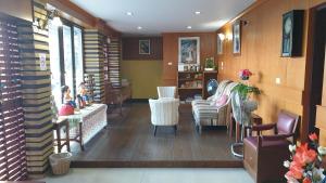 a living room with chairs and a table and a room with at Little Guest House Hotel in Chiang Mai