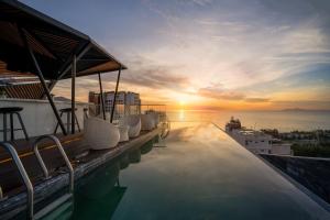 Draco Hotel & Suites في دا نانغ: مسبح مطل على غروب الشمس