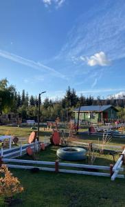 um parque com um parque infantil com dois pneus grandes em Cabañas Vista Hermosa Radal 7 Tazas em El Torreón