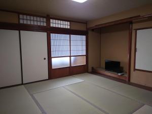 an empty room with a room with a tv in it at Albany inn Shirahama アルバニーイン白浜 in Shirahama