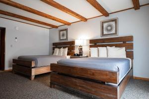 two beds in a hotel room with wooden furniture at Hotel Vienna in Windham