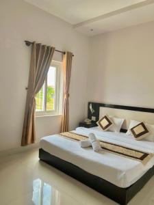 Ấp Khánh Phước (1)的住宿－KHACH SAN HOAN VU，一间卧室设有一张大床和一个窗户。