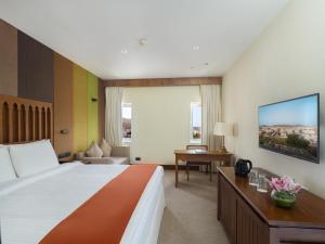 a hotel room with a bed and a living room at Al Falaj Hotel in Muscat