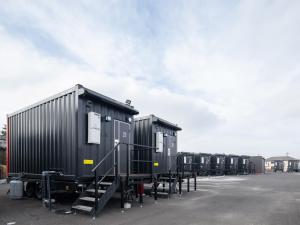 une rangée de wagons garés dans un parking dans l'établissement HOTEL R9 The Yard Sakai, à Sakai