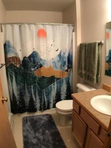 a bathroom with a toilet and a shower curtain at Cozy 2 BR Mountain View - walk to resort in Big Sky