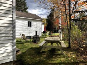 a picnic table in a yard next to a house at Chalet Au Bord du St-Maurice in La Tuque