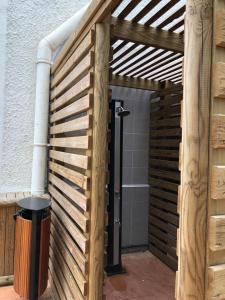 - une entrée en bois pour un bâtiment avec un mur en bois dans l'établissement Studio Cosy, Accès Plage, au Gosier