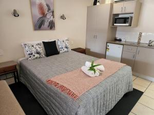 a small bedroom with a bed with a flower on it at Charters Towers Motel in Charters Towers
