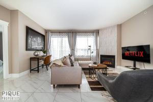 sala de estar con sofá y chimenea en Luxury Downtown Suite, River Valley View, Patio & BBQ, Sleeps 4 en Edmonton