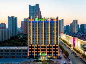 un grand bâtiment avec un panneau en haut dans l'établissement Holiday Inn Express Xinji City Center, an IHG Hotel, à Xinji