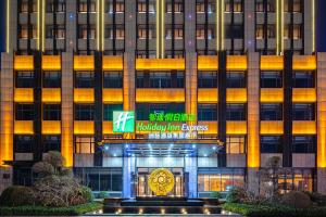 un bâtiment avec un panneau devant lui dans l'établissement Holiday Inn Express Xinji City Center, an IHG Hotel, à Xinji