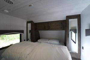 a bedroom with a large white bed with a window at 淡島シーサイドコテージ in Anan