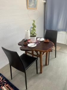 einem Holztisch mit Stühlen und einer Pflanze darauf in der Unterkunft Hunny Home in Ko Yao Noi