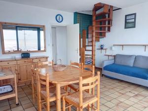 a kitchen and dining room with a table and a couch at Appartement Duplex en Front de Mer avec Terrasse – Accès Direct Plage – 2 Chambres + Cabine - FR-1-361-456 in Saint-Pair-sur-Mer