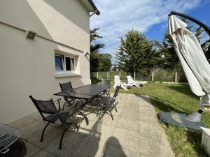 eine Terrasse mit einem Tisch, Stühlen und einem Sonnenschirm in der Unterkunft Appartement Saint-Pair-sur-Mer, 3 pièces, 4 personnes - FR-1-361-455 in Saint-Pair-sur-Mer