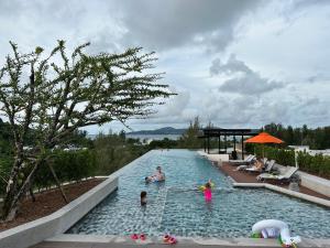 a group of people swimming in a swimming pool at Phuket apartment surin beach in Thalang