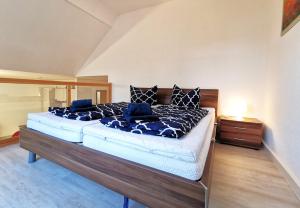 1 dormitorio con 1 cama grande con almohadas azules en Galerie-Ferienwohnung "Im Schindlershof" - zentral und ruhig, en Eibenstock