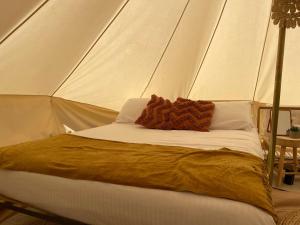 Una cama en una tienda con una manta. en Triple Creek Guest House - Barossa Region, en Seppeltsfield