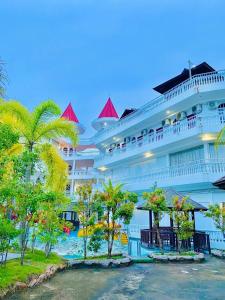 a large cruise ship with palm trees in front of it at Landcons Hotel & Resort in Pantai Cenang