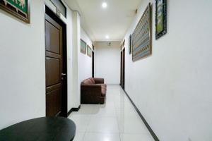 pasillo de una habitación con puerta y sofá en RedDoorz Near Braga Street, en Bandung