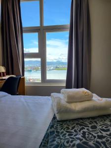 1 dormitorio con 1 cama y ventana grande en Sempre Premier Inn - MACTAN AIRPORT HOTEL, en Mactan
