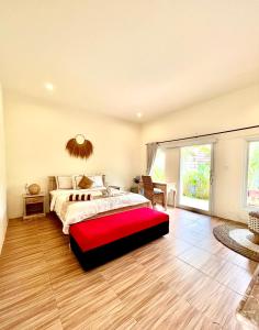 a bedroom with a large bed with a red bench at Agung Wiwin Homestay & Restaurant in Mengwi