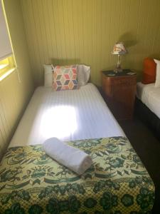 a small bedroom with a bed with a blanket at Vine Valley Inn in Cessnock