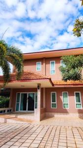 una casa rosa con una palmera delante de ella en Big whole peaceful house, en Udon Thani