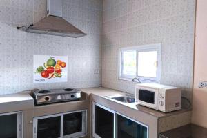 a kitchen with a microwave and a sink at Big whole peaceful house in Udon Thani