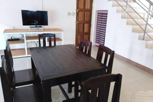 a dining room with a wooden table and chairs at Big whole peaceful house in Udon Thani