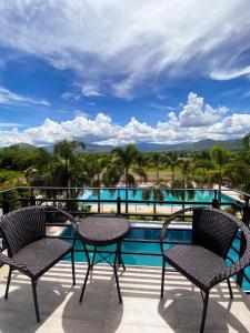 un balcón con 2 sillas y una piscina en Casa De Española Hotel and Resort, en Aritao