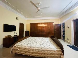 a bedroom with a bed and a flat screen tv at The Choudhury Manor Homestay in Guwahati