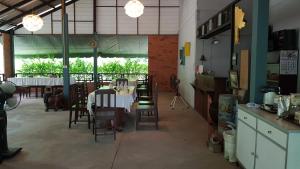 a dining room with a table and some chairs at ที รีสอร์ท T Resort Suphanburi in Ban Noi
