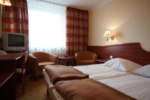 a hotel room with a bed and a desk and a television at Hotel Kamena in Chełm