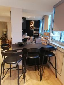 a kitchen with black chairs and a kitchen island at Le Paul Chandon Centre-ville 4 pers in Épernay