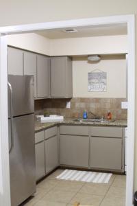 a kitchen with a stainless steel refrigerator and cabinets at New Family Friendly Stay! No Checkout Work! in College Station