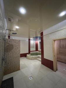 a large bathroom with a shower and a tub at Гостиница Селена in Qyzylorda