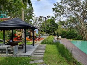 a park with a bench and a pavilion next to a playground at 4-7 Pax Genting View Resort Kempas Residence -Free Wifi, Netflix And Free Parking in Genting Highlands