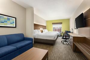 Habitación de hotel con cama y sofá en Holiday Inn Express Hotel and Suites Akron South-Airport Area, an IHG Hotel, en Akron