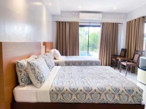 a hotel room with two beds and a balcony at Casa De Española Hotel and Resort in Aritao +82 photos
